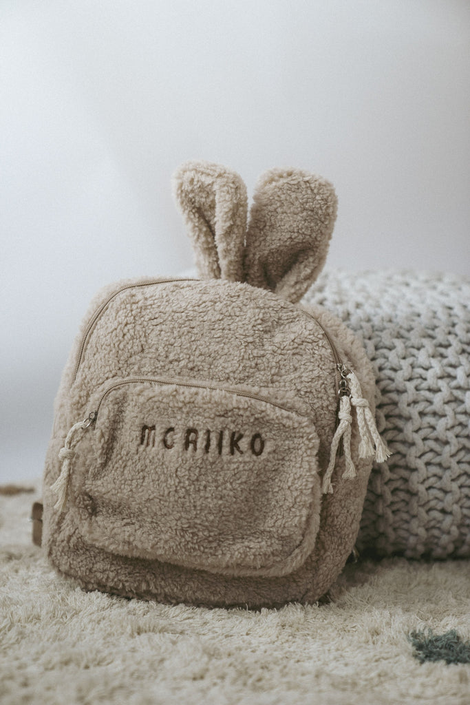 Beiger Rucksack aus Teddy mit einer Aufschrift von Moriiko 