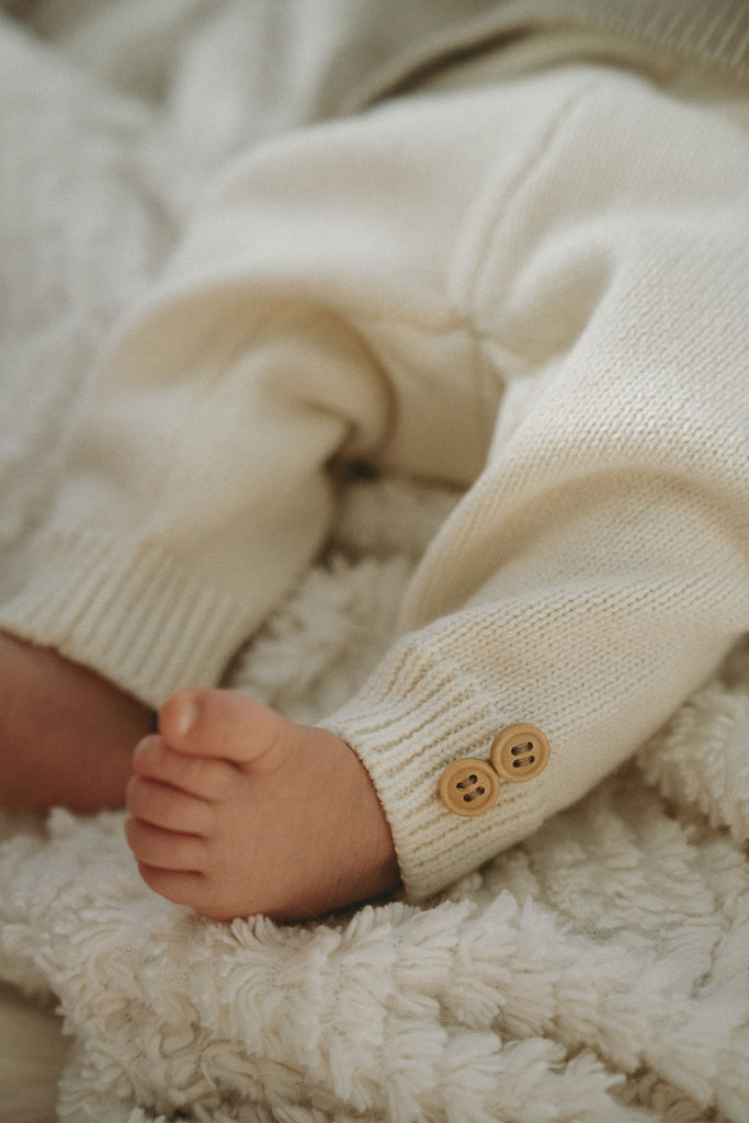 Süße Babyfüße auf einer Decke mit einer Hose aus Baumwolle von Moriiko
